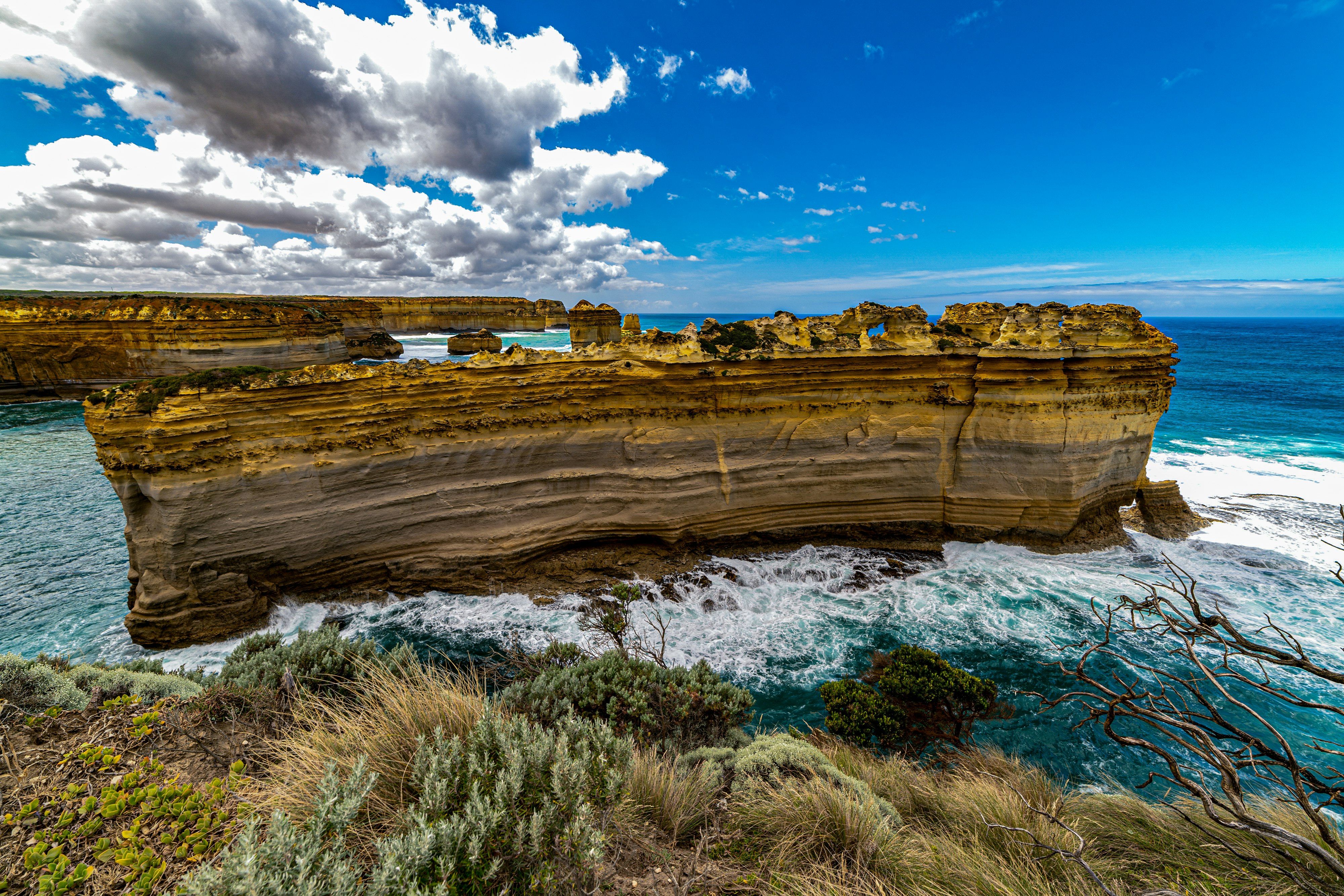 brown rock formation near body of water under blue sky during daytime